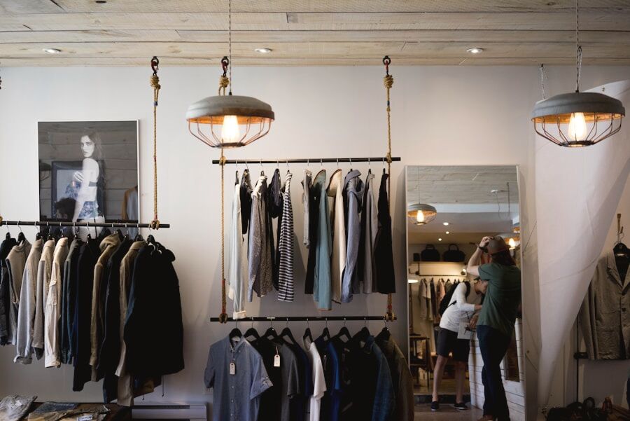 A calm boutique rail of garments in muted tones, warm pendant light overhead